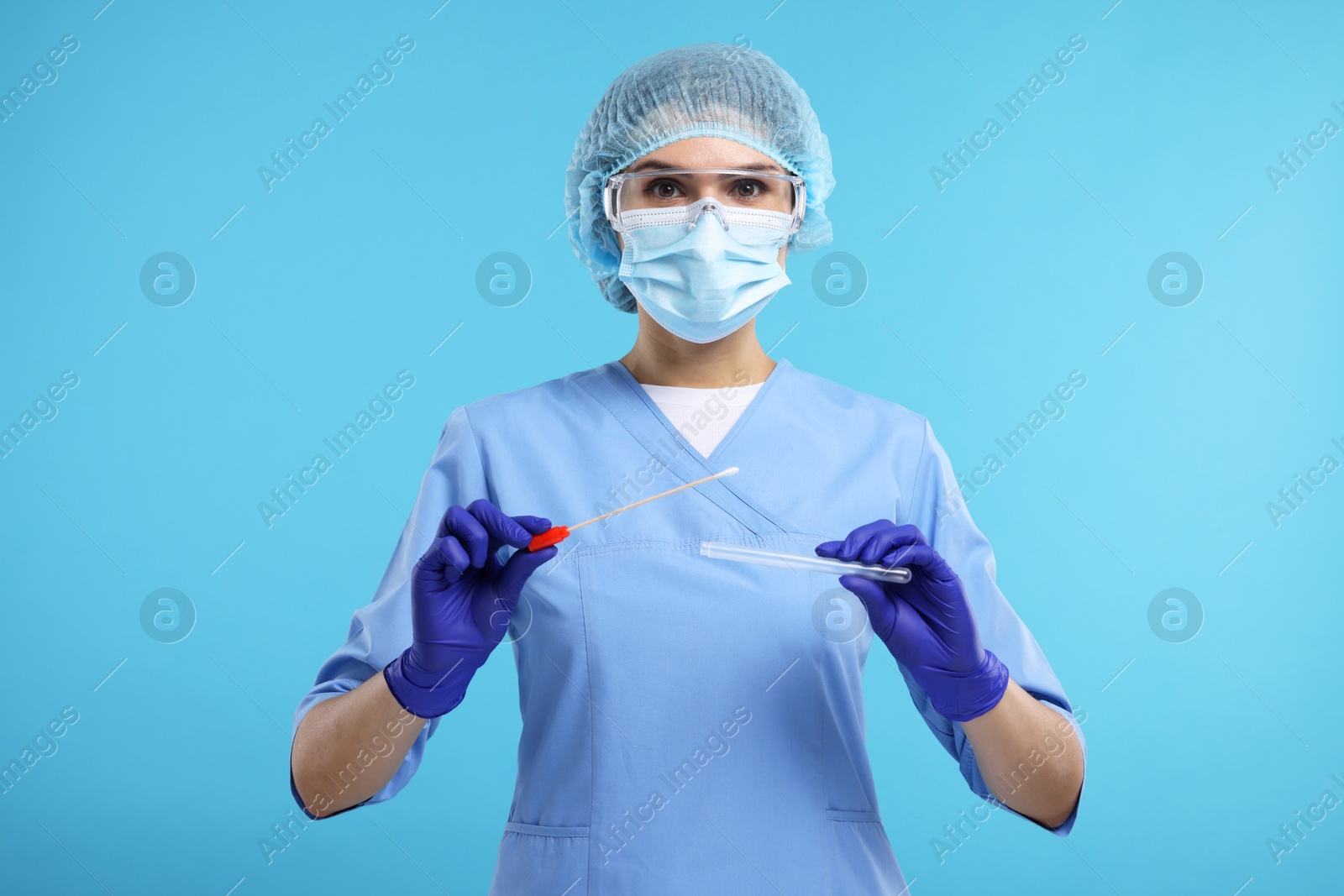 Photo of Laboratory testing. Doctor with cotton swab and tube on light blue background