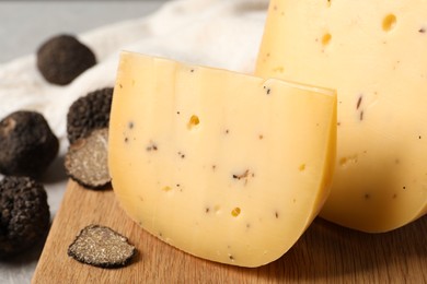 Photo of Delicious cheese and fresh black truffles on table, closeup