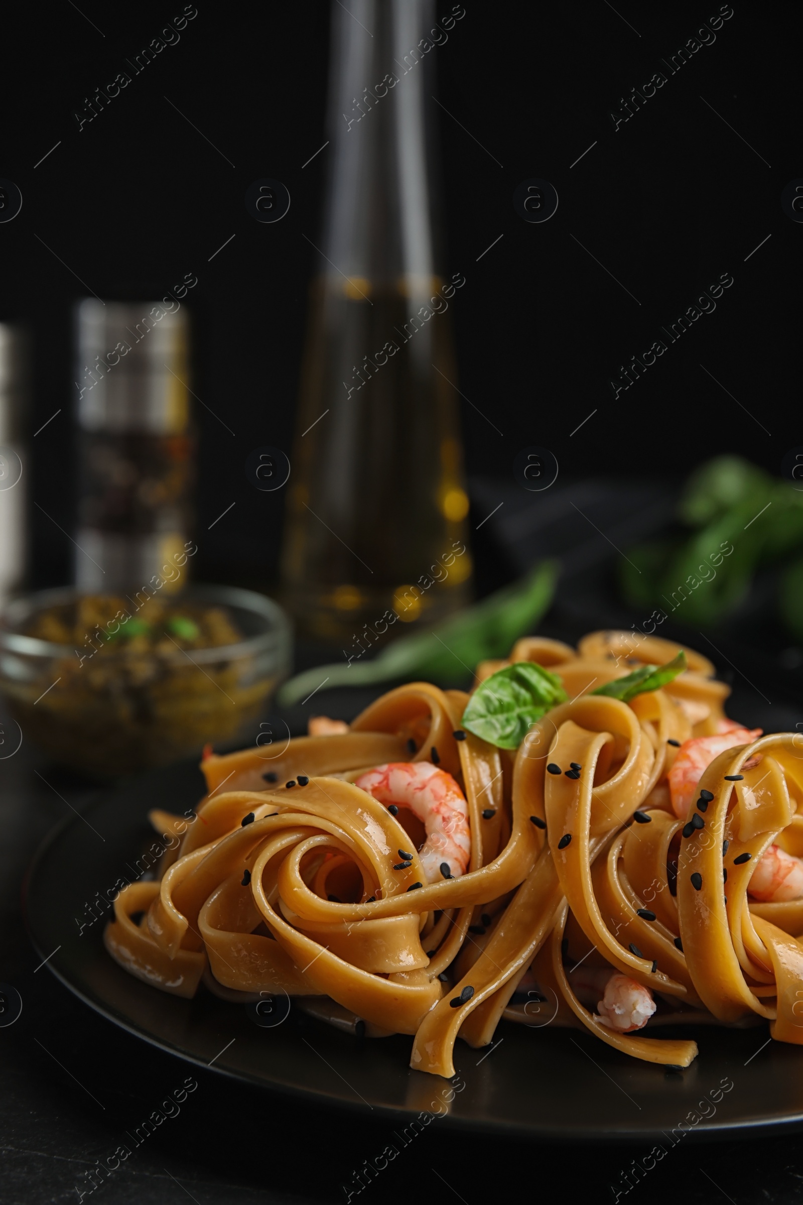 Photo of Tasty buckwheat noodles with shrimps served on black table