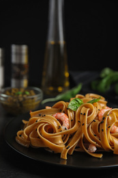 Tasty buckwheat noodles with shrimps served on black table