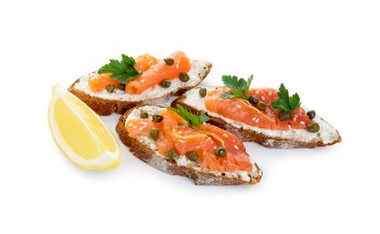 Photo of Tasty canapes with salmon, capers, lemon and cream cheese isolated on white