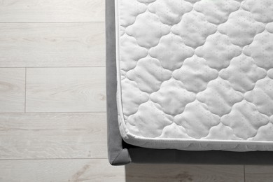 Photo of New light green mattress on gray bed indoors, top view. Space for text