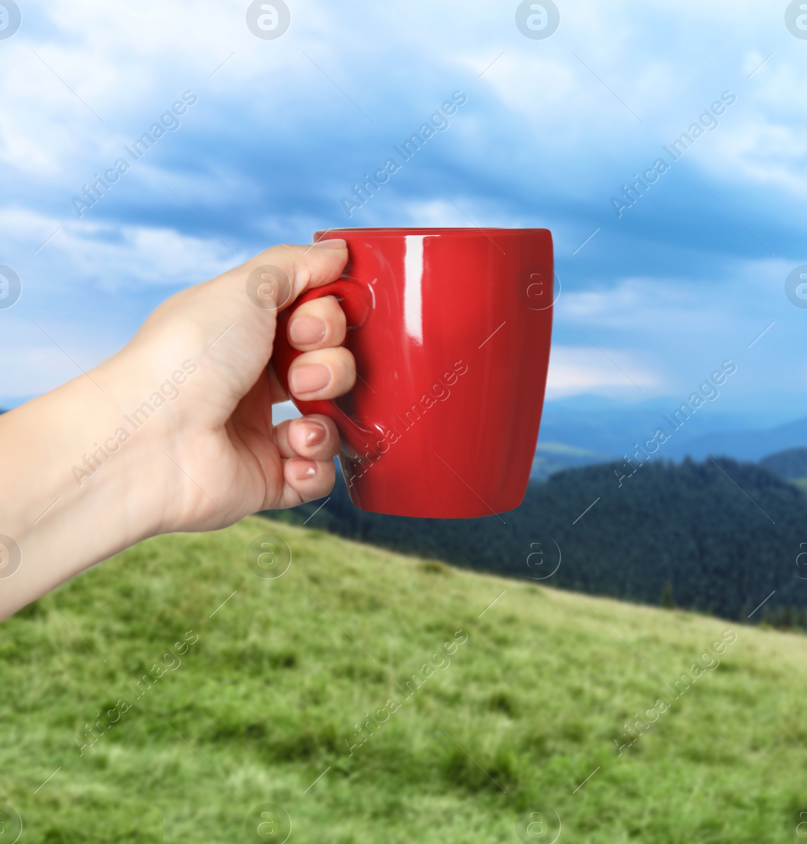 Image of Closeness to nature. Woman holding cup in mountains, closeup