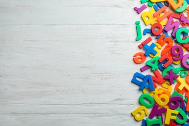 Plastic magnetic letters on wooden background, top view with space for text