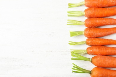 Photo of Flat lay composition with carrots on white table. Space for text