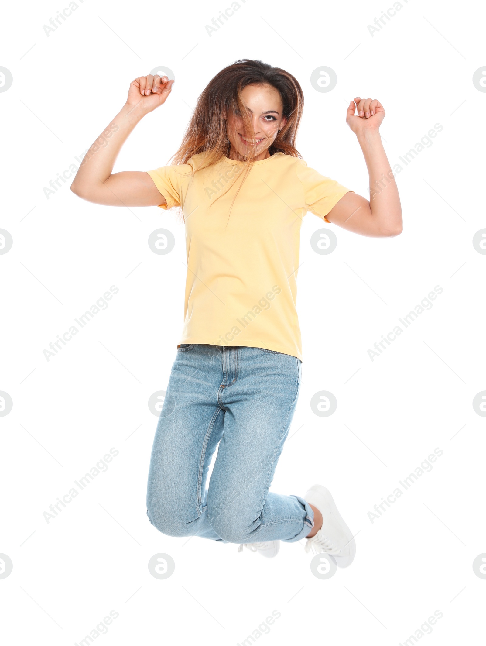 Photo of Happy young woman in casual outfit jumping on white background