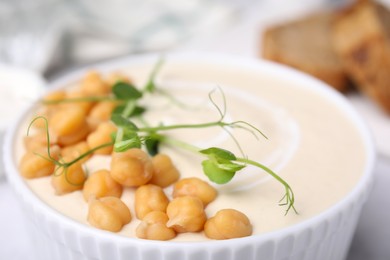 Tasty chickpea soup in bowl served on table, closeup