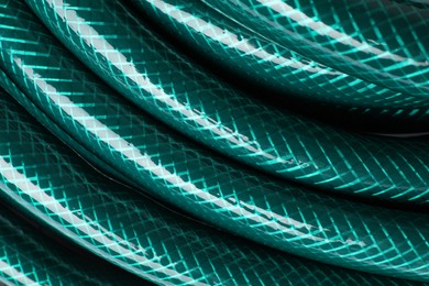 Photo of Green rubber watering hose as background, closeup