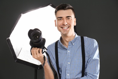 Young photographer with professional camera in studio