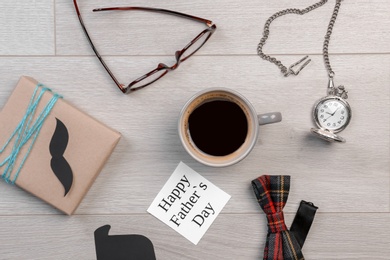 Composition with gift box and cup of coffee on wooden background. Father's day celebration