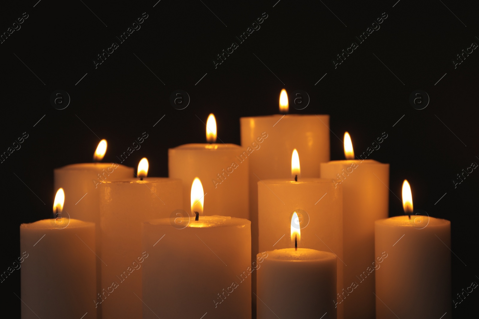 Photo of Burning candles on dark background. Symbol of sorrow