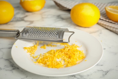 Lemon zest and fresh fruits on white marble table