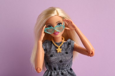 Photo of Mykolaiv, Ukraine - September 4, 2023: Beautiful Barbie doll with stylish eyeglasses on lilac background