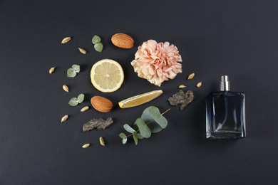 Photo of Flat lay composition with bottle of perfume on black background