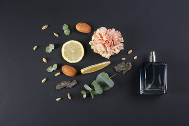 Flat lay composition with bottle of perfume on black background