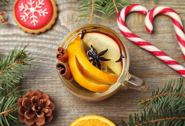 Photo of Aromatic mulled wine on wooden table, flat lay
