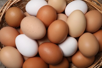 Fresh chicken eggs in wicker basket, top view