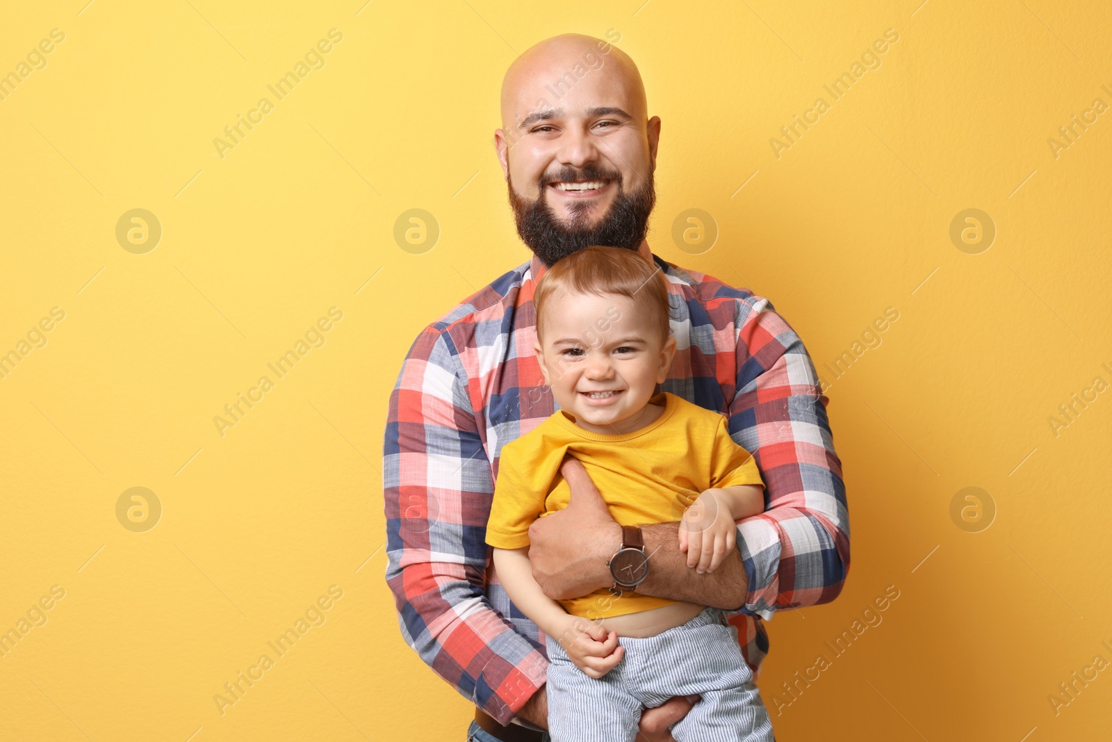 Photo of Portrait of dad and his little son on color background