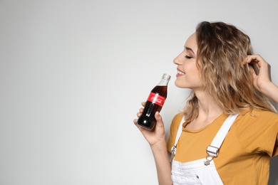 MYKOLAIV, UKRAINE - NOVEMBER 28, 2018: Young woman with bottle of Coca-Cola on white background, space for text