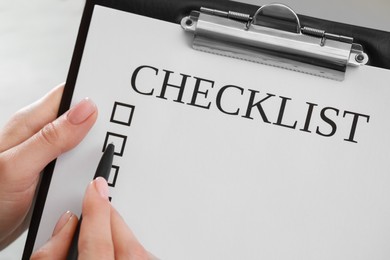 Woman filling Checklist with pen, closeup view