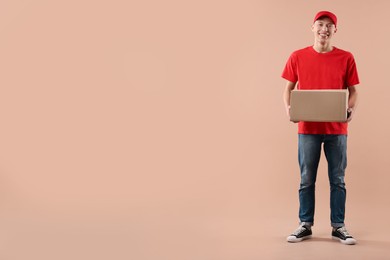 Photo of Happy courier with parcel on beige background. Space for text