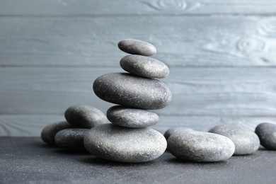 Photo of Stacked zen stones on table against wooden background