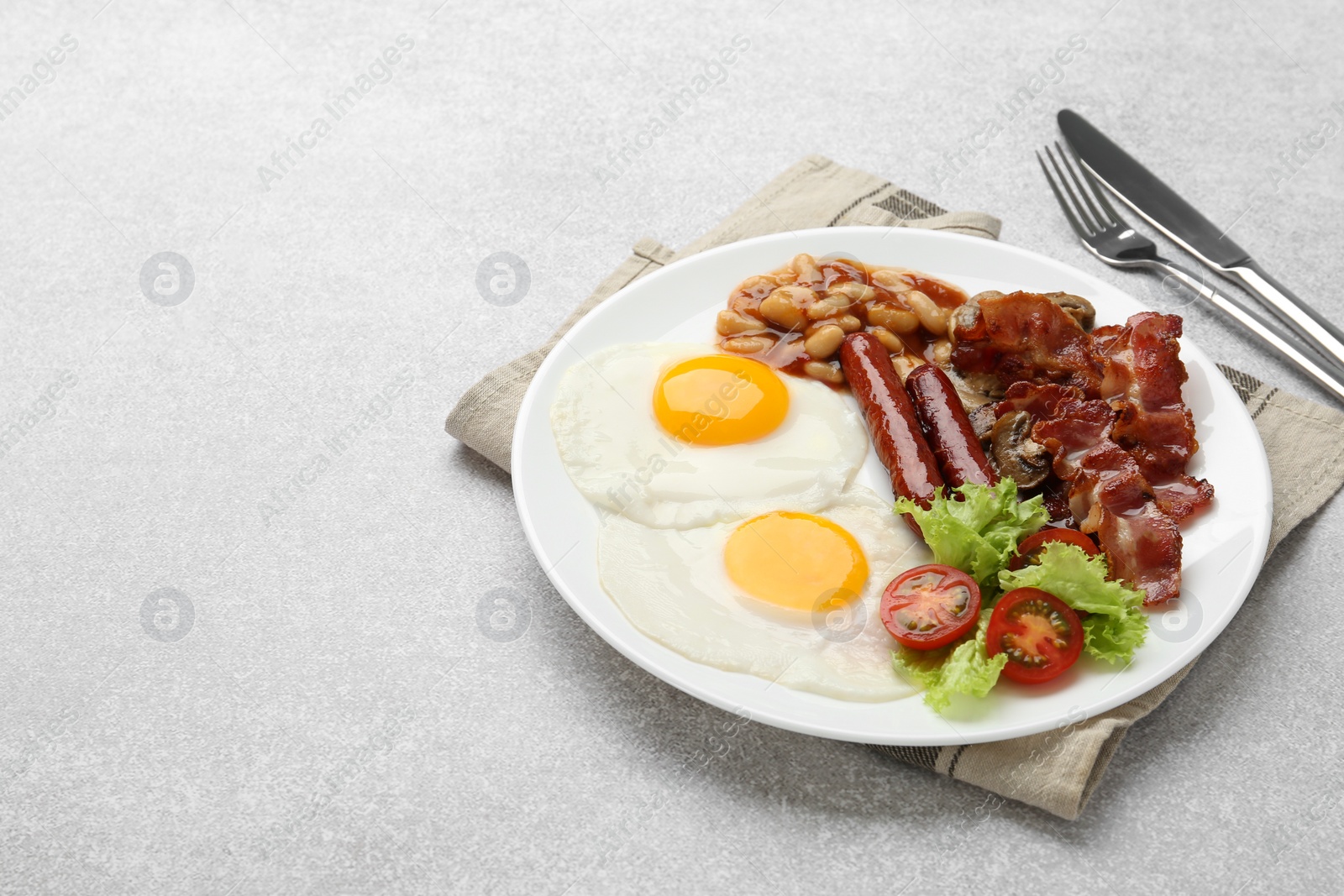 Photo of Delicious breakfast with sunny side up eggs on light table. Space for text