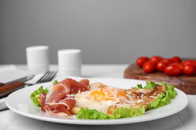 Photo of Delicious crepe with egg served on white tiled table. Breton galette