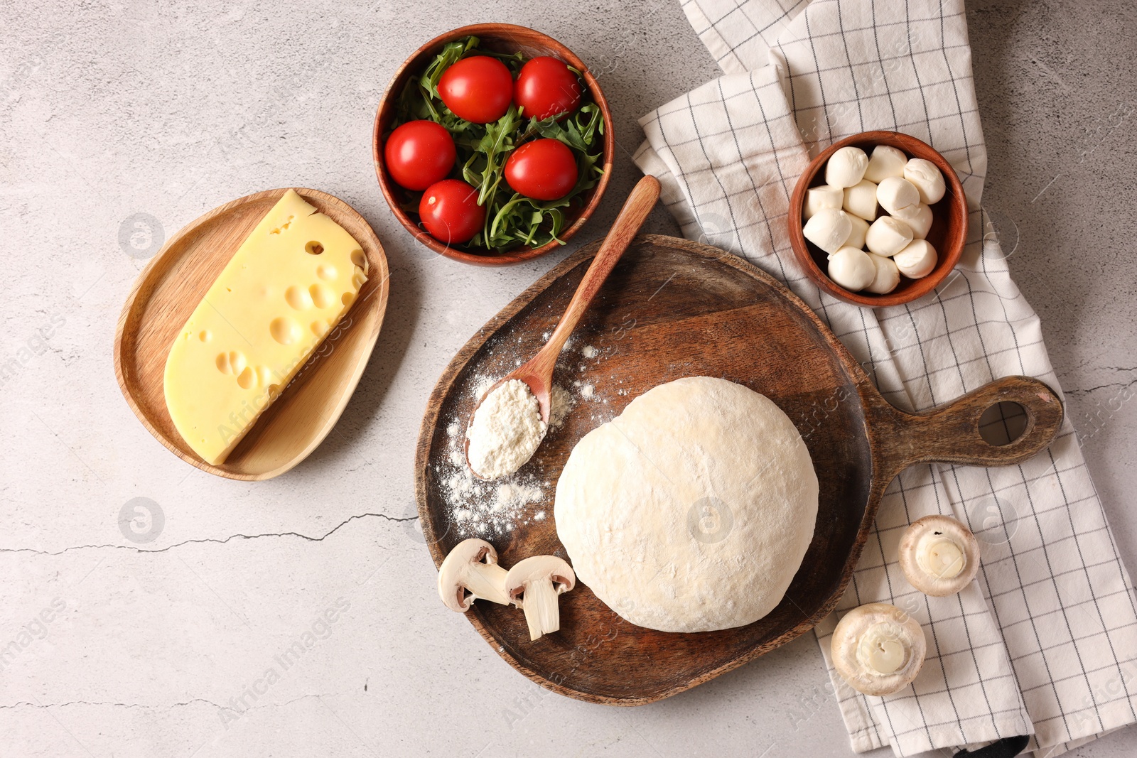 Photo of Pizza dough and products on gray textured table, flat lay