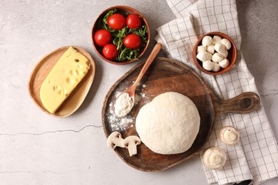 Photo of Pizza dough and products on gray textured table, flat lay