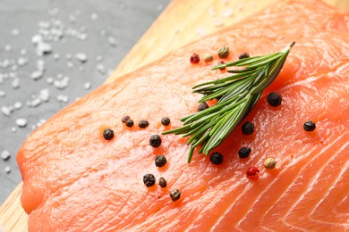 Fresh raw salmon and ingredients for marinade on board, closeup