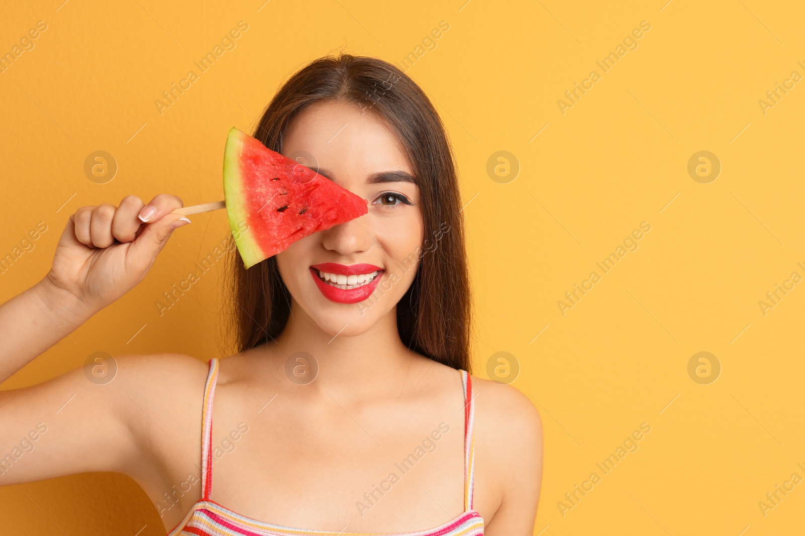 Photo of Beautiful young woman posing with watermelon on color background