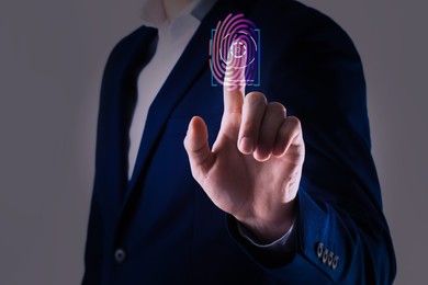 Man using biometric fingerprint scanner on grey background, closeup
