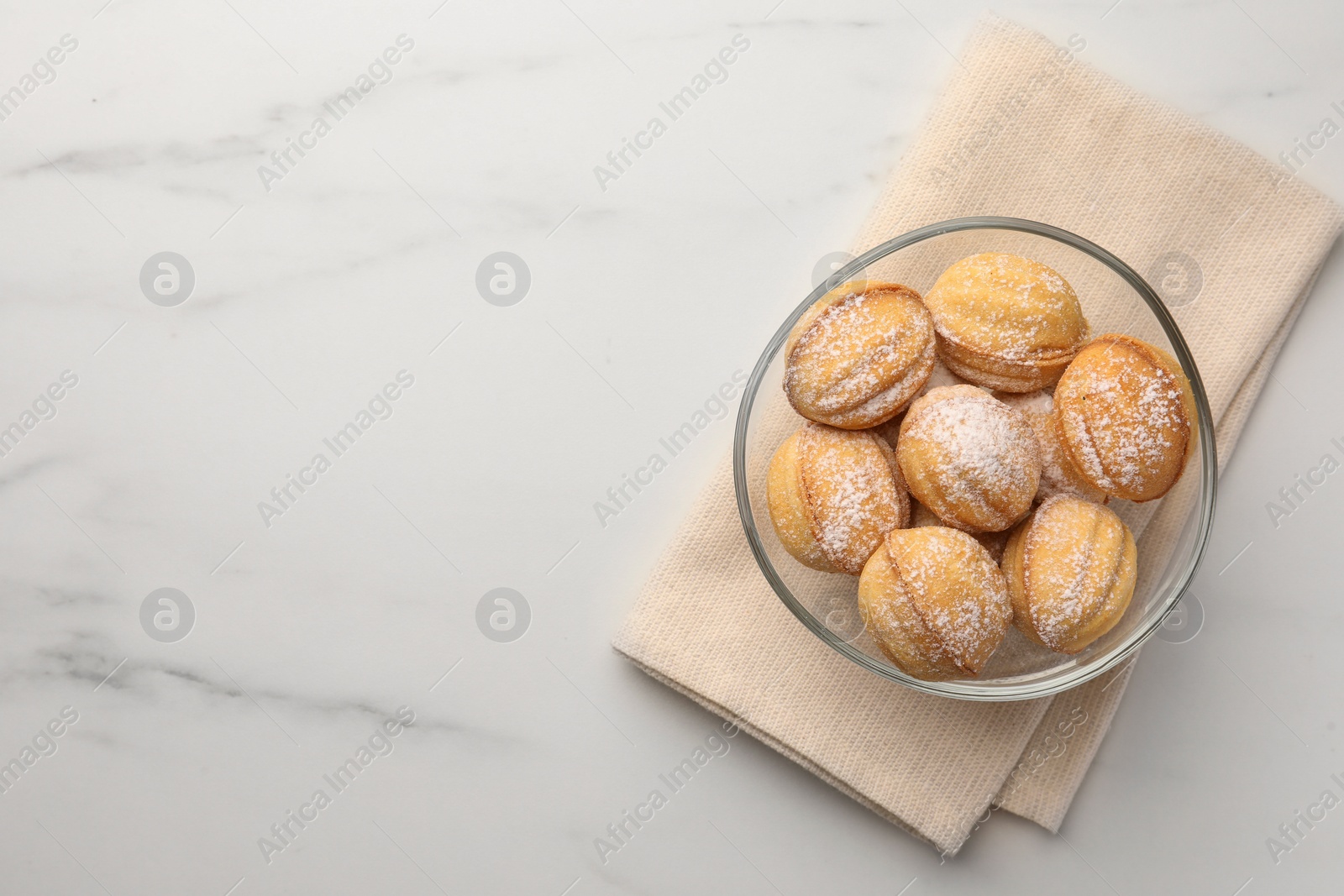 Photo of Homemade walnut shaped cookies with condensed milk on white marble table, top view. Space for text