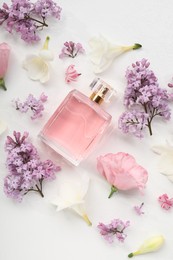 Photo of Luxury perfume and floral decor on white background, flat lay