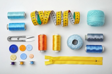 Photo of Composition with color sewing threads on white background