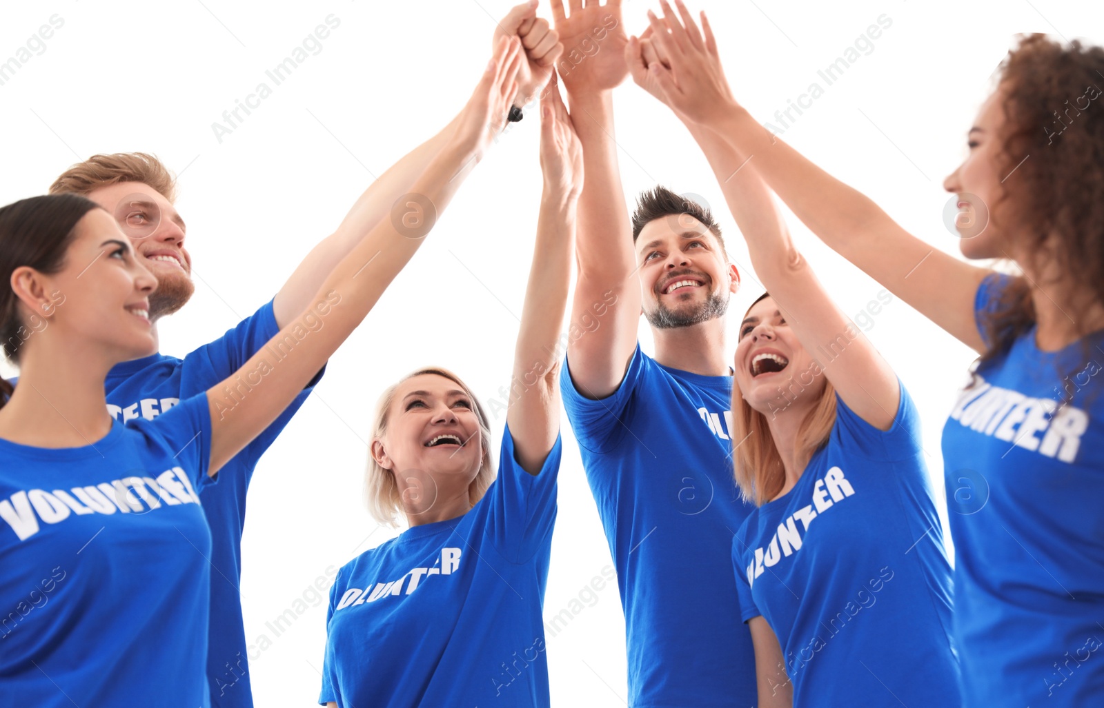 Photo of Team of volunteers putting hands together on light background