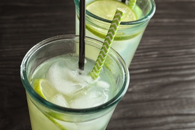 Photo of Natural lemonade with lime in glasses on table, closeup