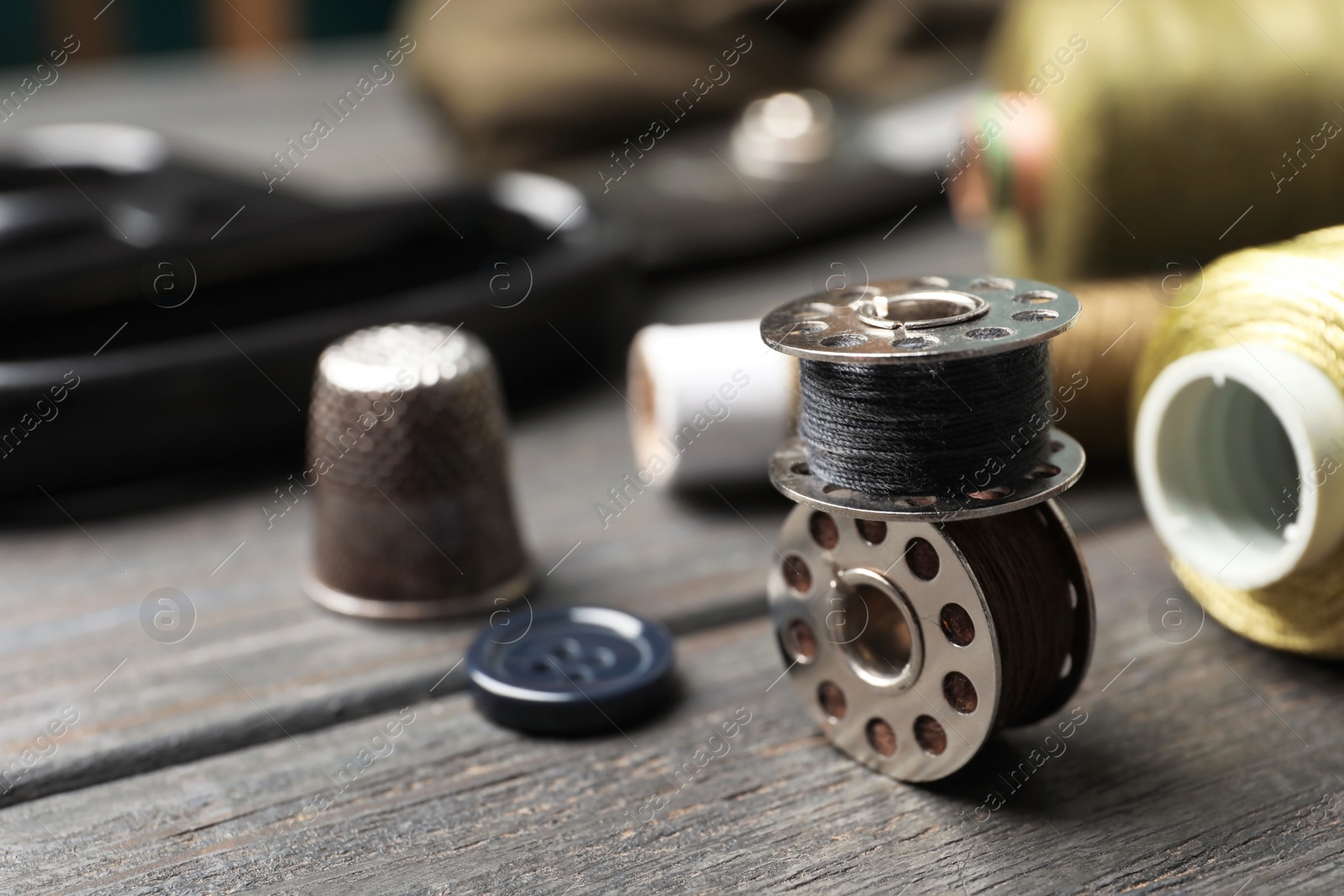 Photo of Bobbins with threads on table. Tailoring accessories