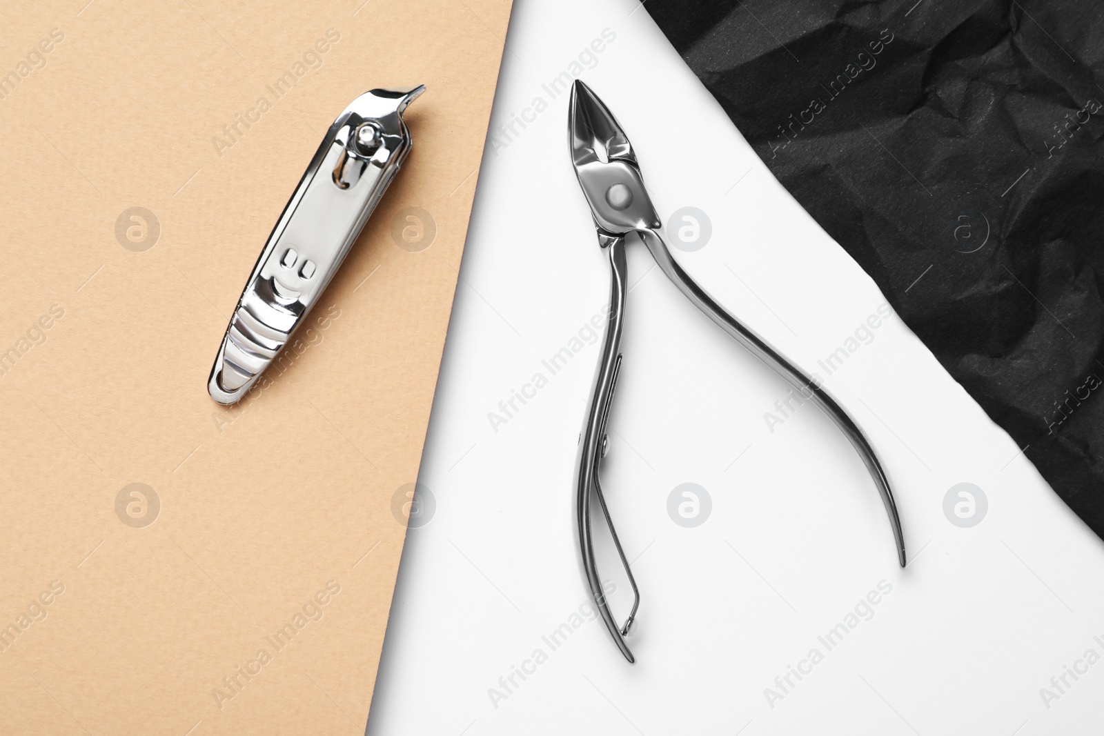 Photo of Nail clippers and cuticle nipper on color background, flat lay. Manicure tools