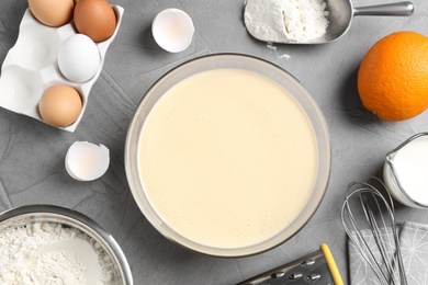 Flat lay composition with batter and ingredients on grey table