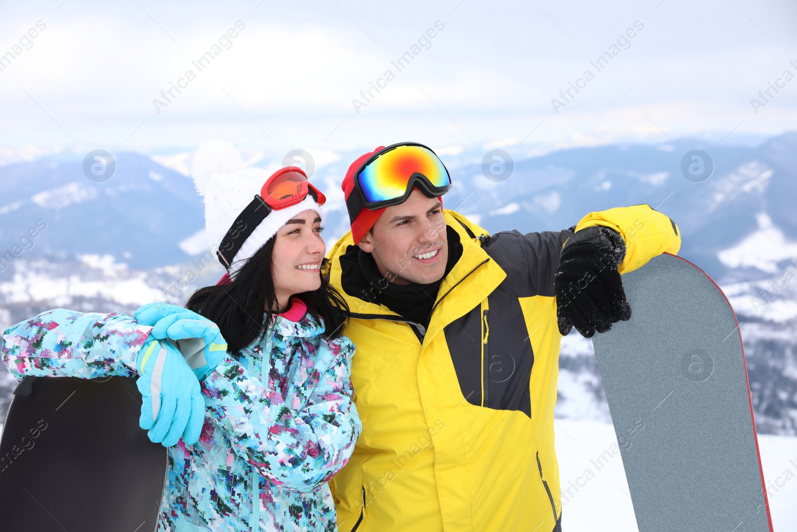 Photo of Couple with snowboards at mountain resort. Winter vacation