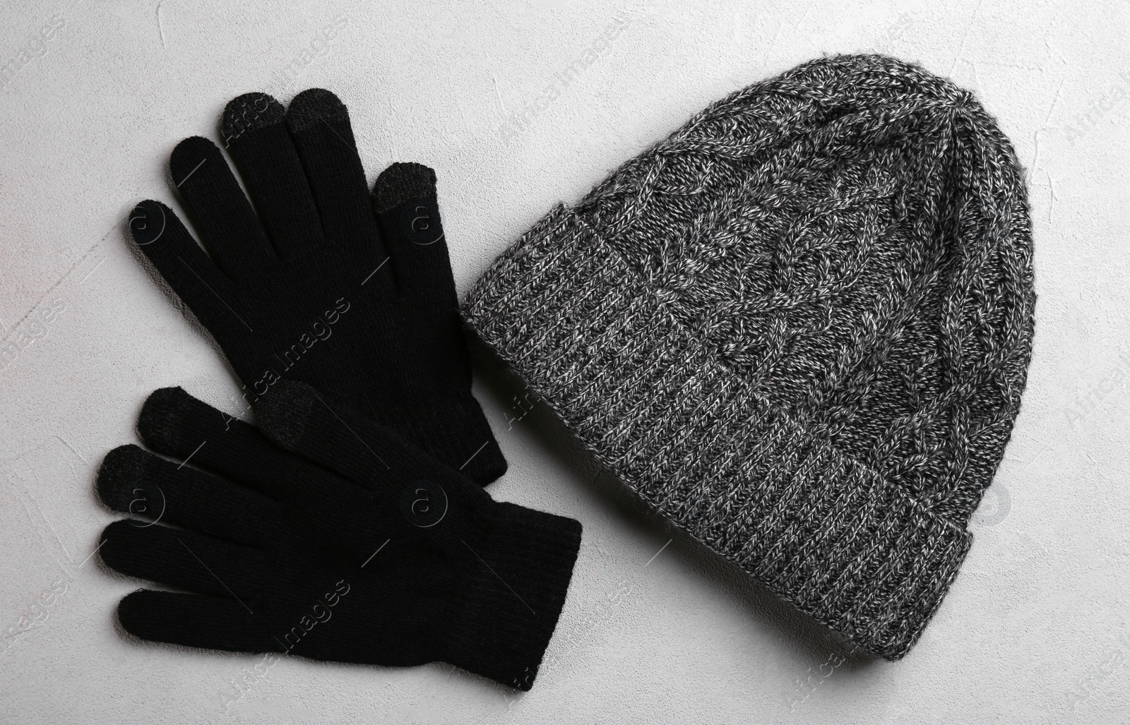 Photo of Stylish gloves and hat on grey background, flat lay