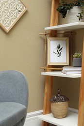 Photo of Bamboo frame and different decor elements on shelving unit indoors