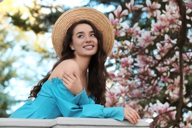 Photo of Beautiful woman near blossoming magnolia tree on spring day