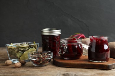 Photo of Delicious pickled beets and spices on wooden table