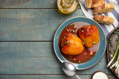 Delicious stuffed peppers served on blue wooden table, flat lay. Space for text