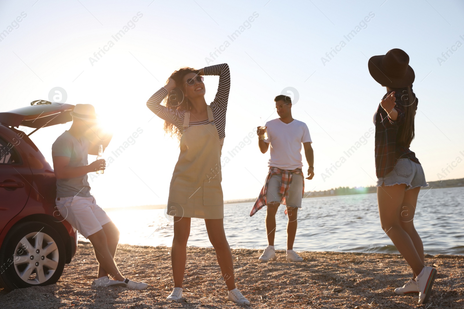 Photo of Happy friends having fun near car on beach. Summer trip