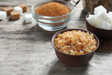 Bowl with brown sugar on wooden background