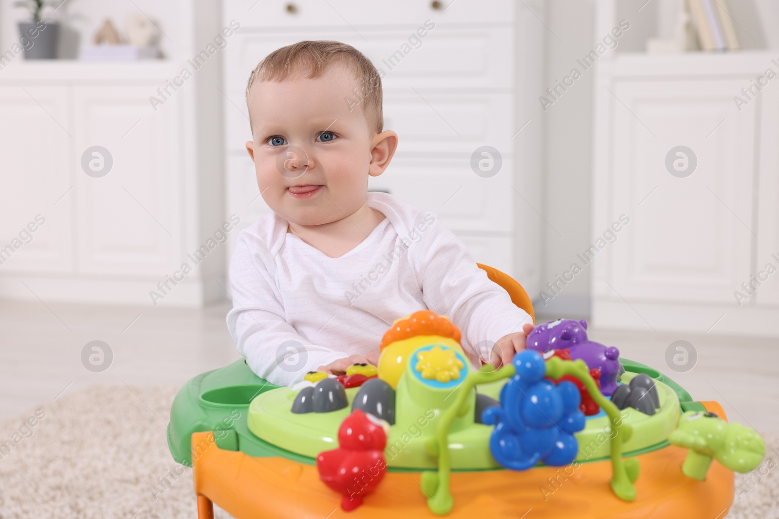 Photo of Portrait of cute baby with toy walker at home. Learning to walk